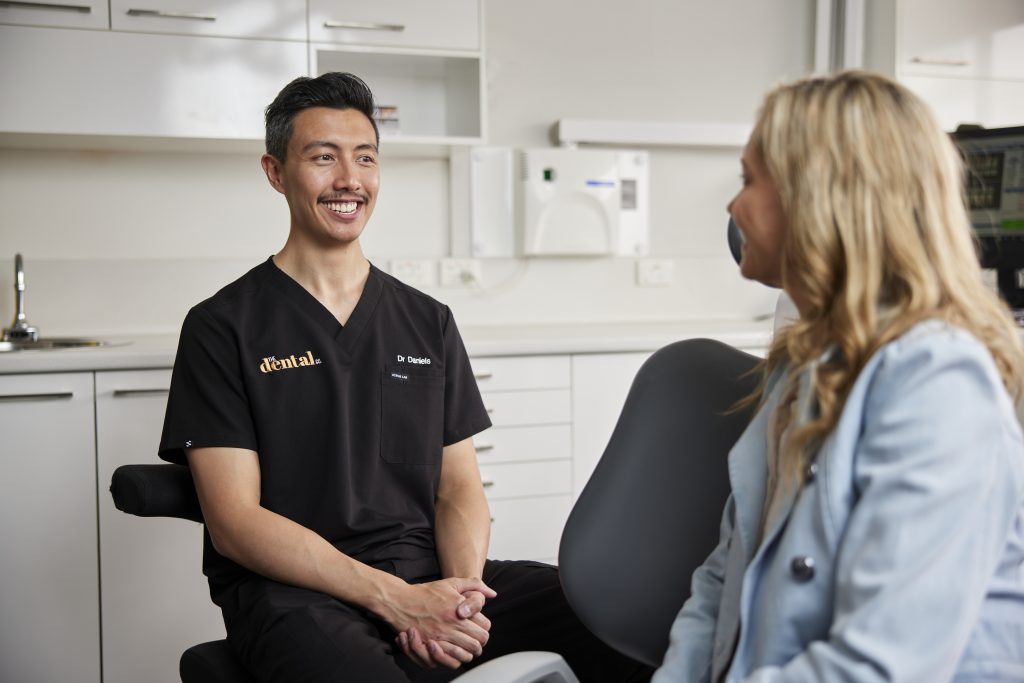 A dentist at The Dental Co. talking with a patient